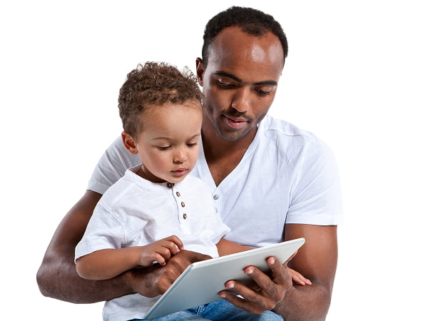 A man and a child sit together against a plain white background, sharing a moment of connection
