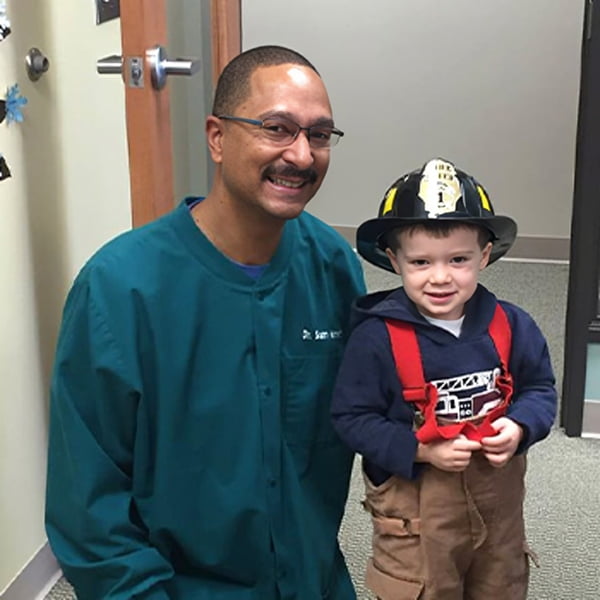 Dr. Sam and a child in a dentist office, preparing for a dental check-up